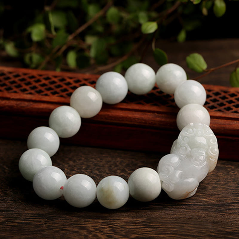 Jade PiXiu Bracelet – Resting on dark wooden table with foliage, elegant display, jade luck protection