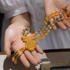 Golden Silk Jade Flower Pendant Necklace – warm earth tone beads with carved rose centerpiece, held across two hands