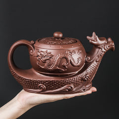 Vintage Dragon Auspicious Clouds Teapot – hand-held terracotta dragon teapot on black background, size reference visible