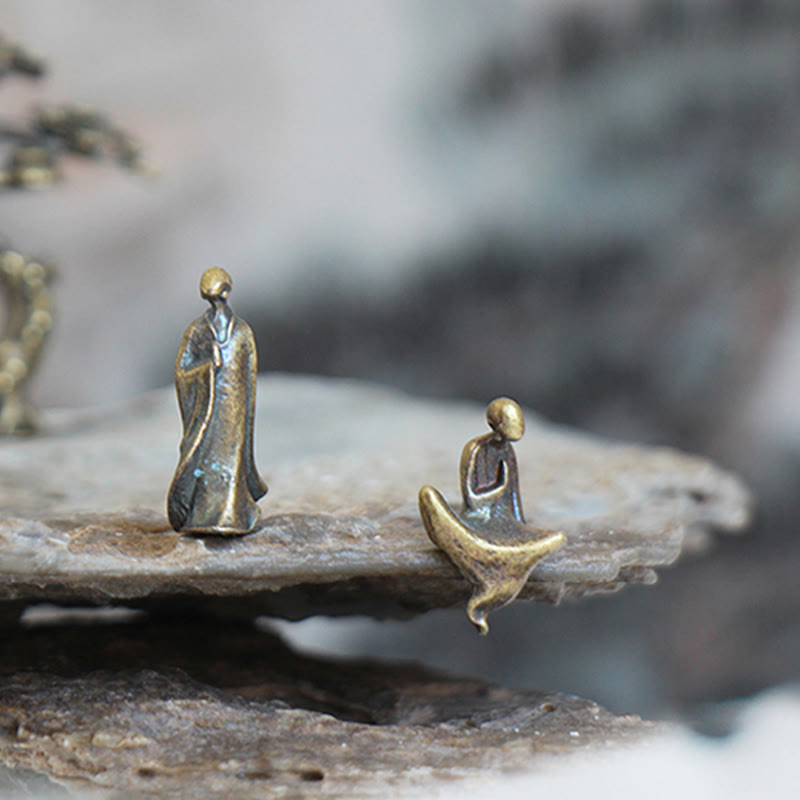 Mini Metal Meditation Buddha Decoration – standing and seated bronze monk figures on natural rock, spiritual harmony