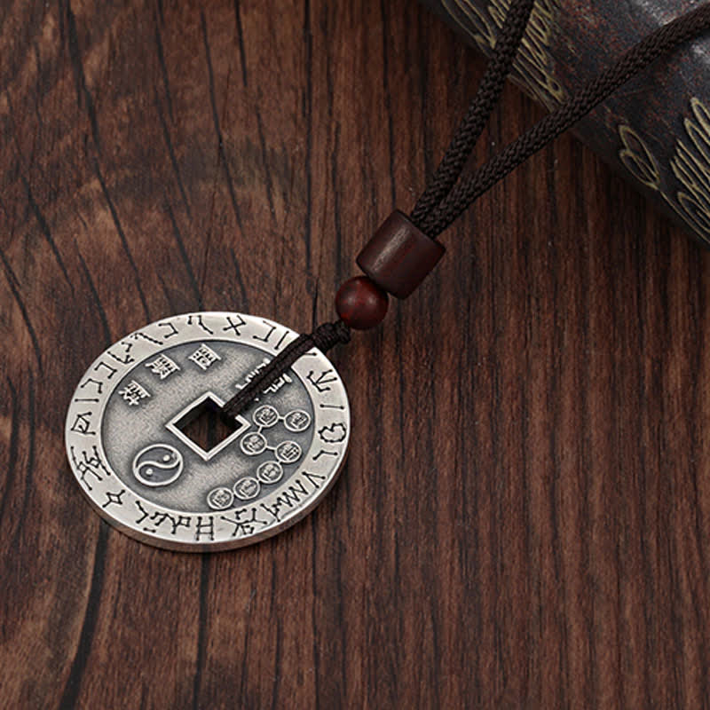 Bagua Yin Yang Obsidian Necklace - silver coin with yin-yang engravings on cord, wooden background