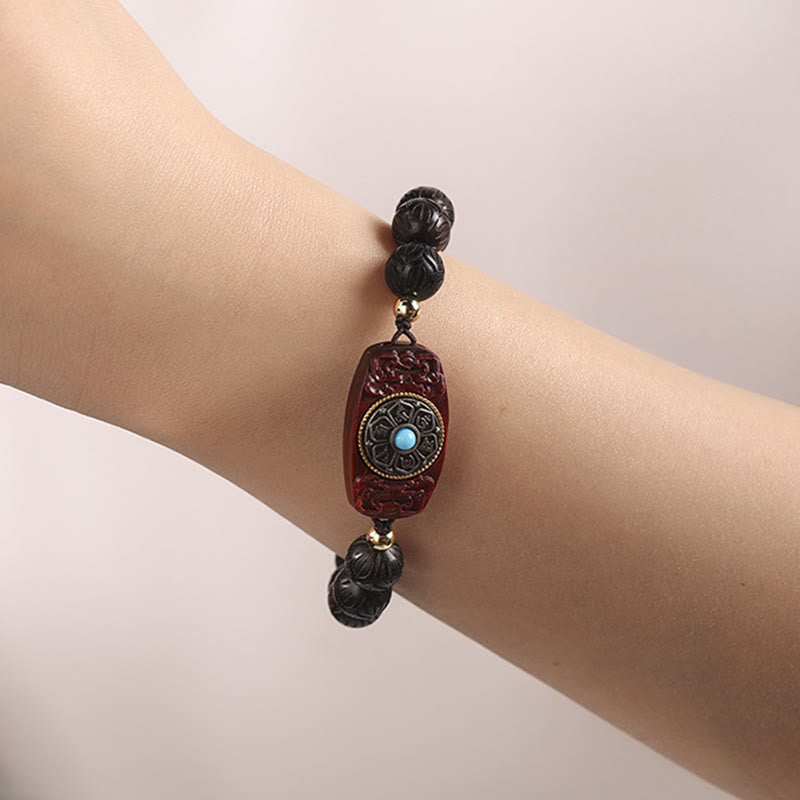 Green Sandalwood & Ebony Soothing Bracelet – wrist shot with burgundy carved centerpiece, lotus mandala design and turquoi...