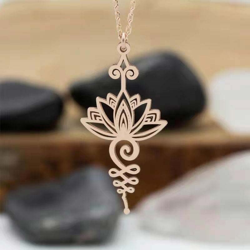 Lotus Luck Wealth Titanium Necklace – rose gold lotus pendant with bokeh river stone backdrop, zen