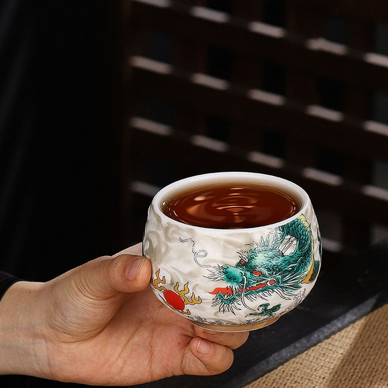 Dragon Cicada Ceramic Tea Bowl - hand-held green dragon cup with 3D cloud texture, amber tea inside, artisan porcelain