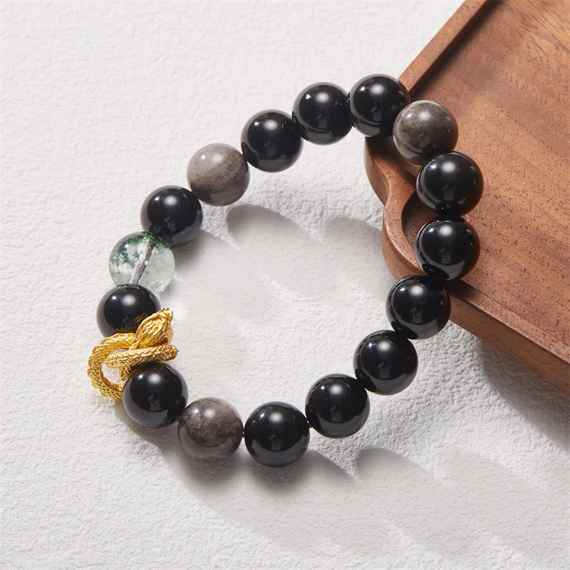 Silver Sheen Obsidian Dragon Bracelet – 45-degree shot on wooden tray with phantom quartz accent and dragon, balanced