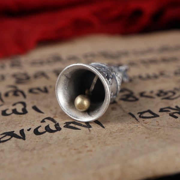 925 Silver Dorje Bell Pendant – Interior view of brass clapper inside silver bell on sutra background