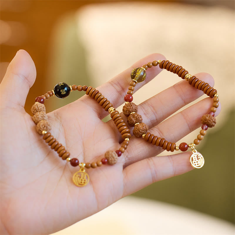 Bodhi Seed Bracelet – Two bracelets on hand showing beads and fortune charms, beaded jewelry