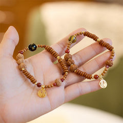 Bodhi Seed Bracelet – Two bracelets on hand showing beads and fortune charms, beaded jewelry