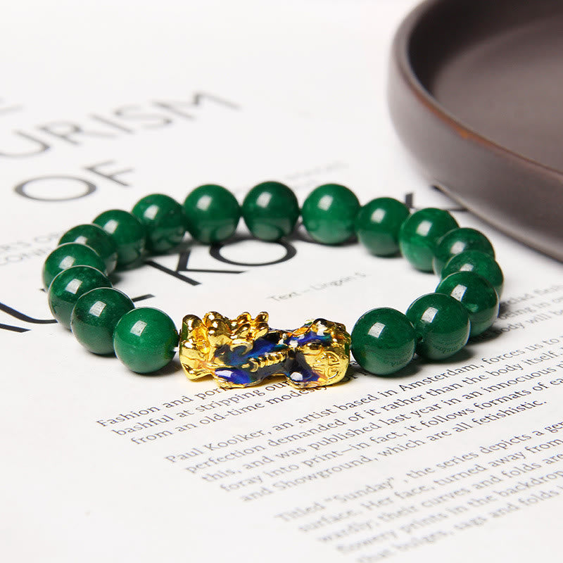 Jade Pixiu Bracelet – On printed newspaper with teacup, lifestyle setting gold-blue PiXiu, good luck charm