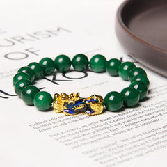 Jade Pixiu Bracelet – On printed newspaper with teacup, lifestyle setting gold-blue PiXiu, good luck charm