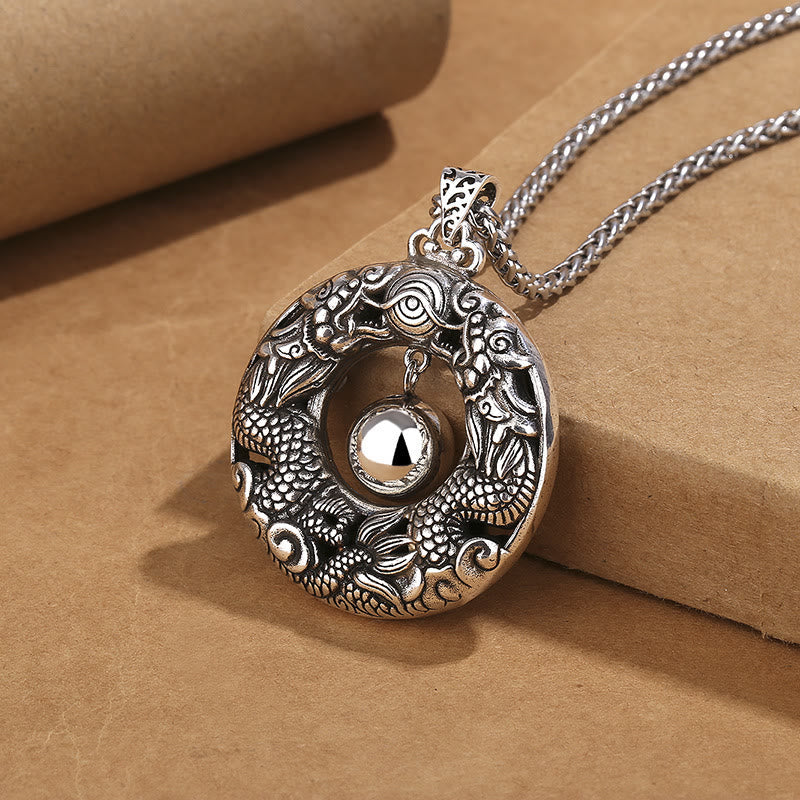 Double Dragon Pendant Necklace three-quarter view, oxidized copper detail, rolled paper prop, protection jewelry