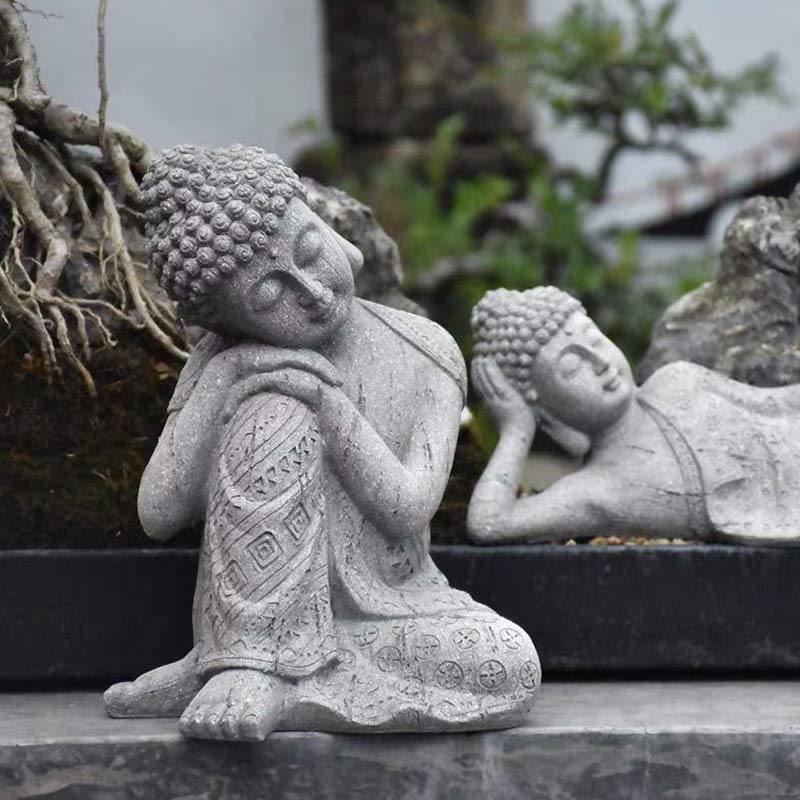 Tibetan Meditation Buddha Resin Decoration – serene Buddha pair nestled by tree roots and stones, natural outdoor display, spiritual garden art