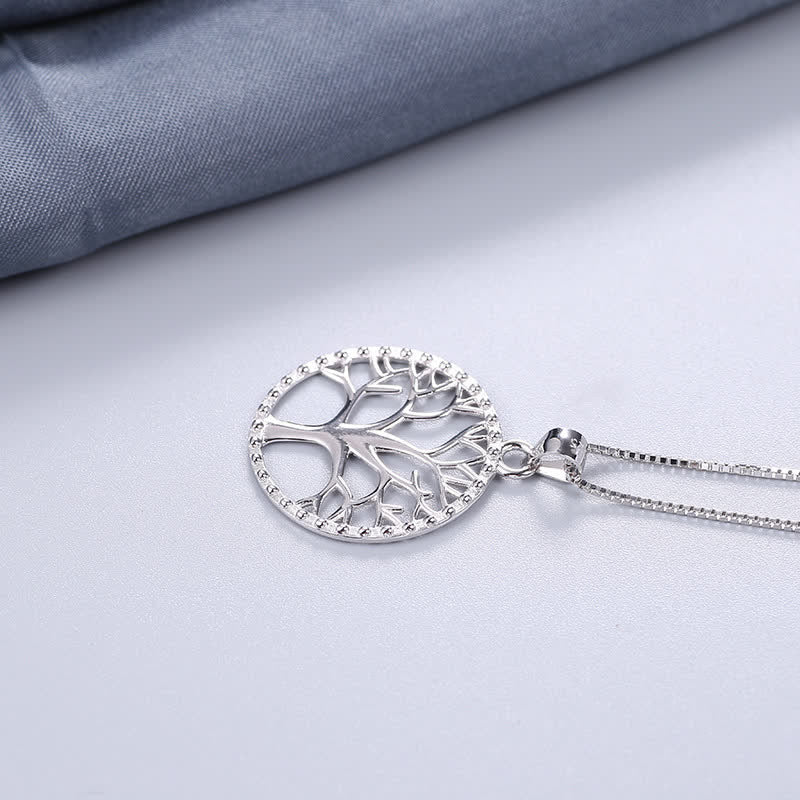 Tree of Life Sterling Silver Necklace – tree pendant with beaded border on light gray surface, diagonal, 925 silver
