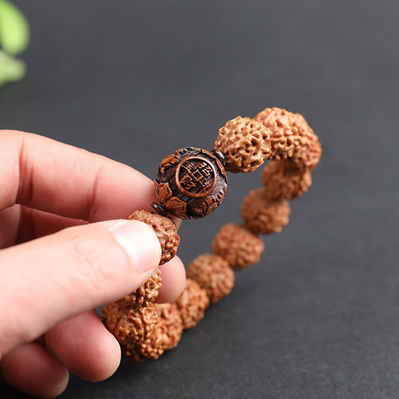 Rudraksha PiXiu Bracelet – Fingers holding carved copper coin bead with bodhi seeds, detail shot
