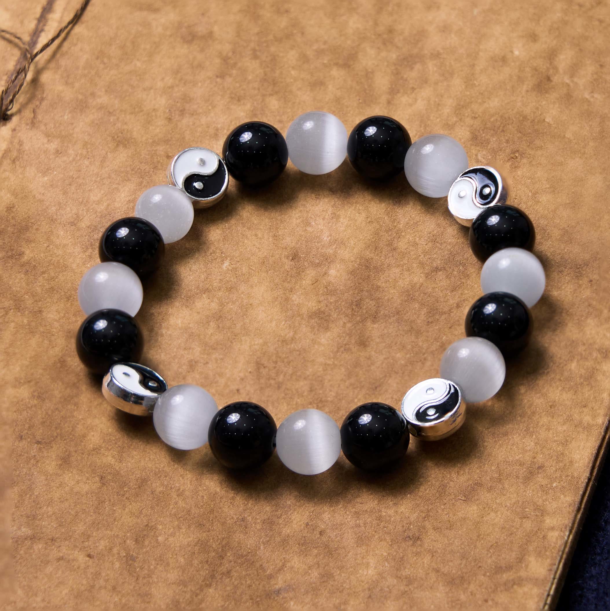 Black Obsidian Cat Eye Yin Yang Bracelet - alternating black obsidian and white cat eye beads with silver yin-yang spacers flat lay, yin-yang bracelet