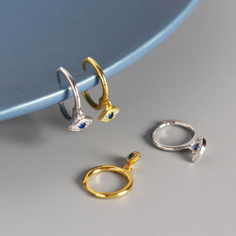 Evil Eye Huggie Hoop Earrings Hanging on Blue Ceramic Plate, Sterling Silver Protection