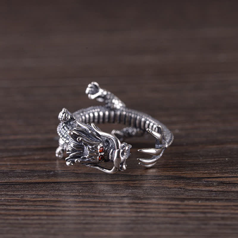 925 Sterling Silver Dragon Ring – Side profile showing dragon head with fangs and red eyes on dark wood grain, Fierce