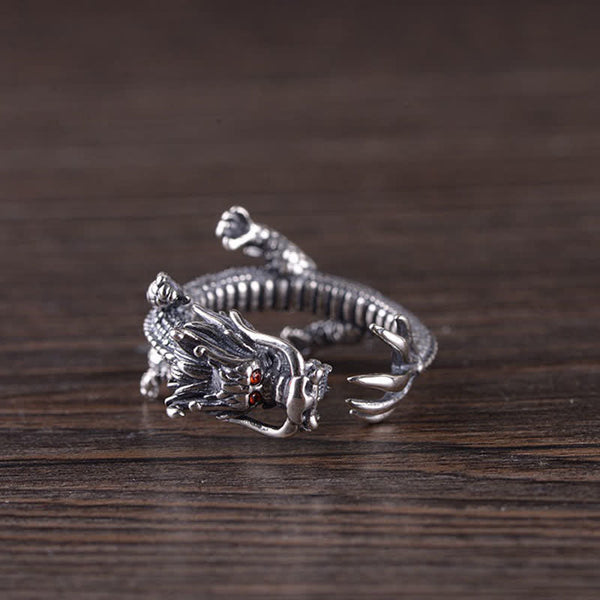 925 Sterling Silver Dragon Ring – Side profile showing dragon head with fangs and red eyes on dark wood grain, Fierce