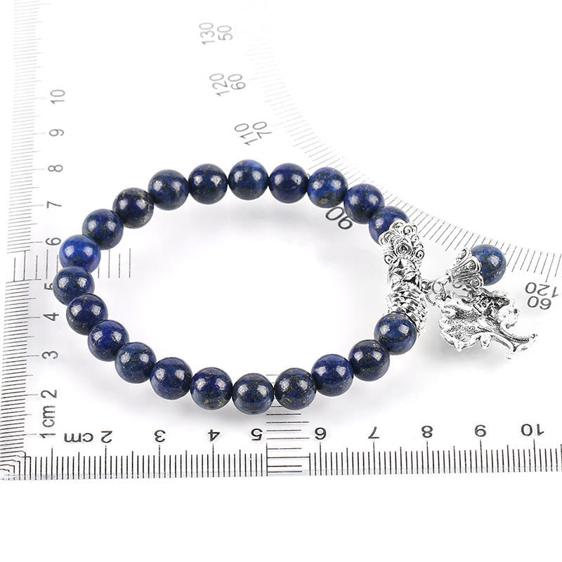 Tree of Life lapis lazuli bracelet with deep blue pyrite-flecked beads, silver decorative clasp with elephant charm, shown on measuring ruler.