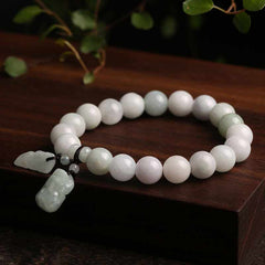 Natural Jade Pi Xiu Buddha Gourd Apple Success Bracelet – jade bracelet on dark wood with green leaves, zen style