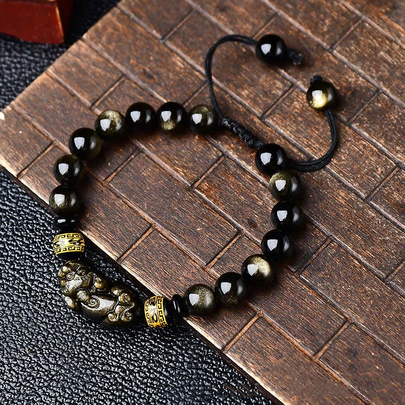 Gold Sheen Obsidian Pixiu Bracelet – Close-up on textured wood showing Pixiu and gold spacers, lucky bead