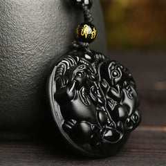 Double PiXiu Necklace – Black obsidian double PiXiu disc pendant close-up on carved wood, spiritual purification necklace