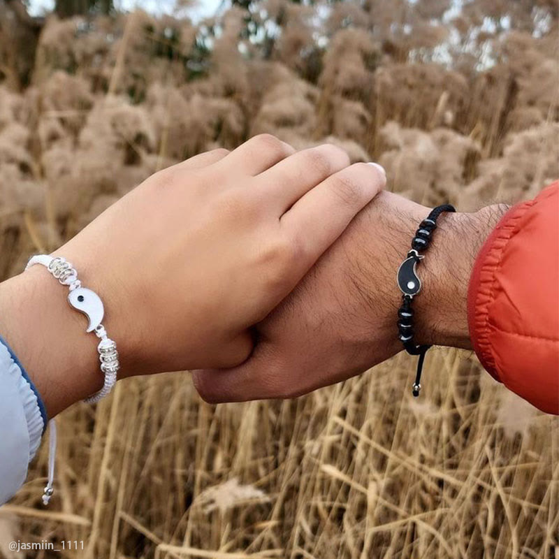 Yin Yang Hematite Bracelet - Black & white couple bracelets on clasped hands outdoors, friendship jewelry