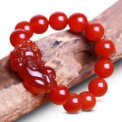 Red Agate PiXiu Wealth Luck Bracelet – red agate PiXiu bracelet on natural wood branch, wealth luck talisman