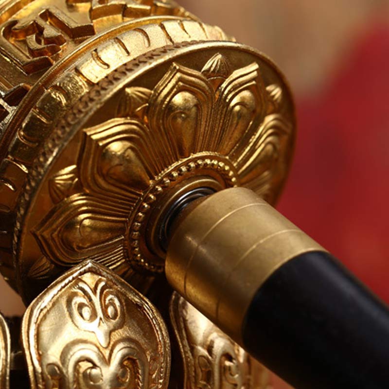 Copper Meditation Prayer Wheel – Macro of gold mantra cylinder and black handle, lotus detail