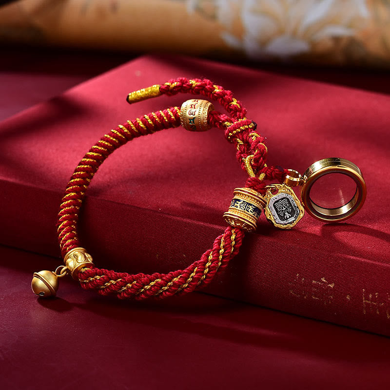 Red and gold cord bracelet with blue pendant, angled view