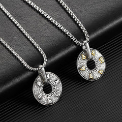 Tibetan Om Mani Padme Hum Peace Buckle Necklace – Two silver disc pendants with gold animal accents, one silver one gold-detail, on black leather surface diagonal