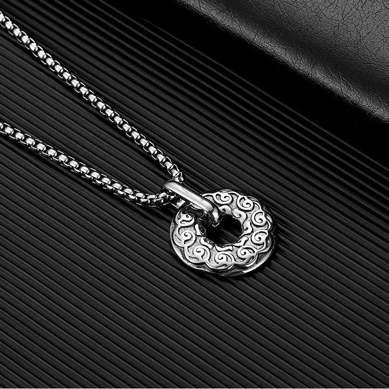Tibetan Om Mani Padme Hum Peace Buckle Necklace – Silver donut pendant with Chinese cloud scroll patterns and central hole on black ribbed surface, diagonal angle