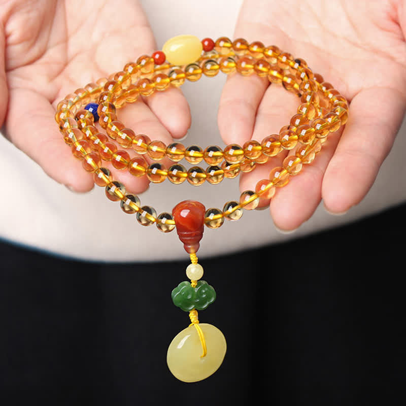 Citrine Mala Bracelet – Hands holding citrine mala beads with red agate and green jade pendant