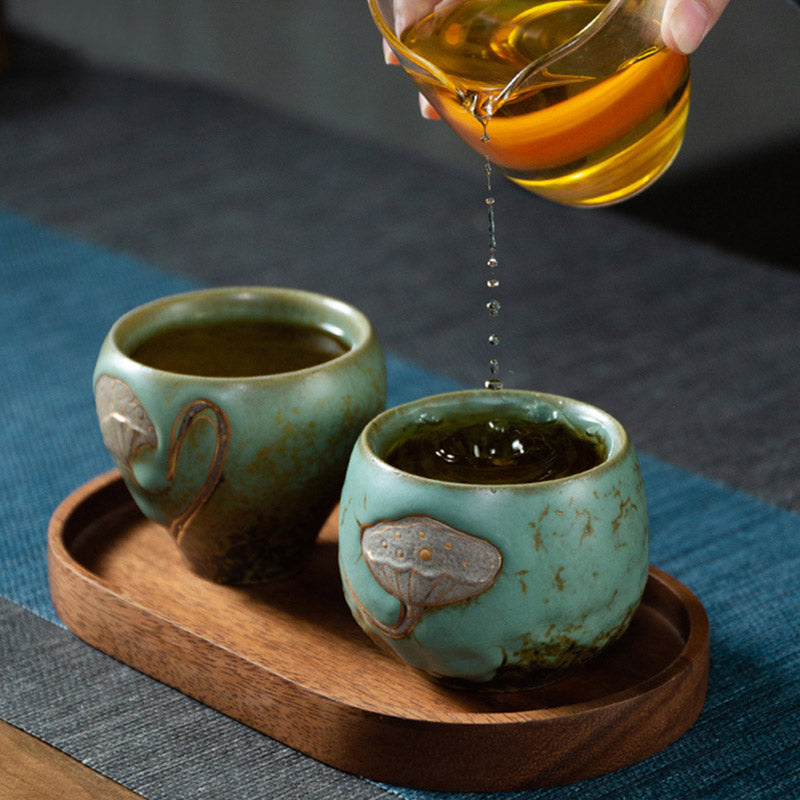 Lotus Pod Ceramic Kung Fu Tea Cup - Green glazed pair on wooden tray with tea pouring action, traditional