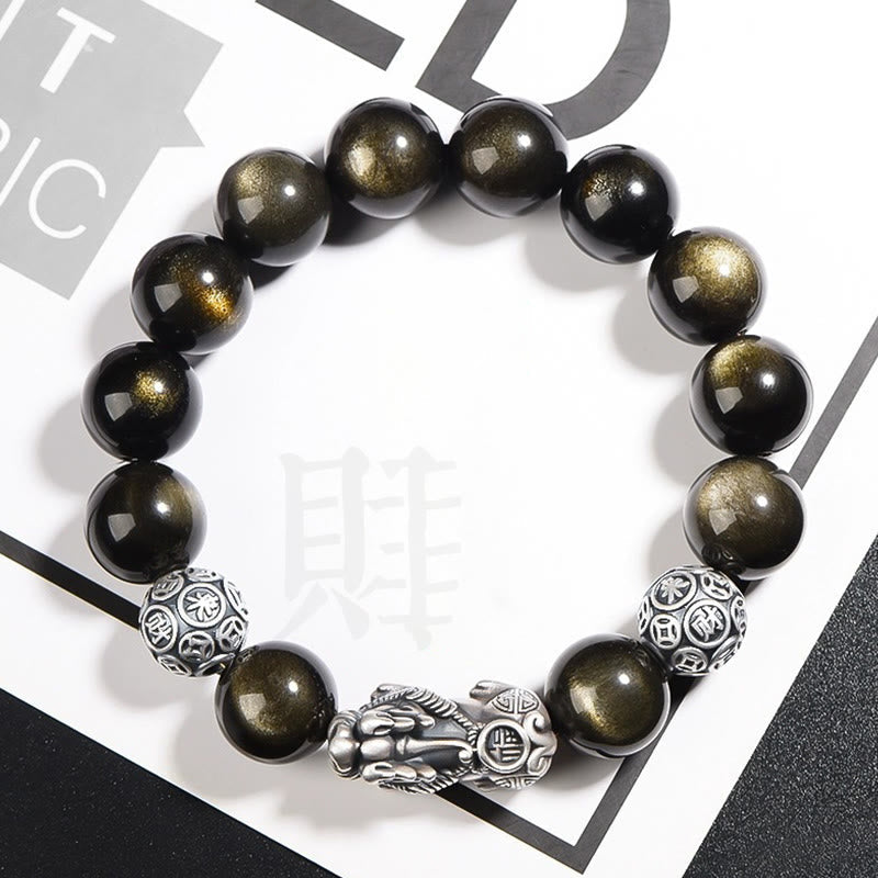 Gold Sheen Obsidian PiXiu Bracelet – Black gold-sheen beads with silver PiXiu on white magazine backdrop, wealth