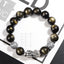 Gold Sheen Obsidian PiXiu Bracelet – Black gold-sheen beads with silver PiXiu on white magazine backdrop, wealth