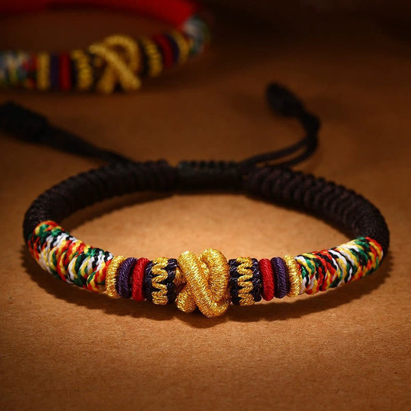 Tibetan Mantra Bracelet – Black cord with gold endless knot and rainbow woven sections, adjustable bracelet