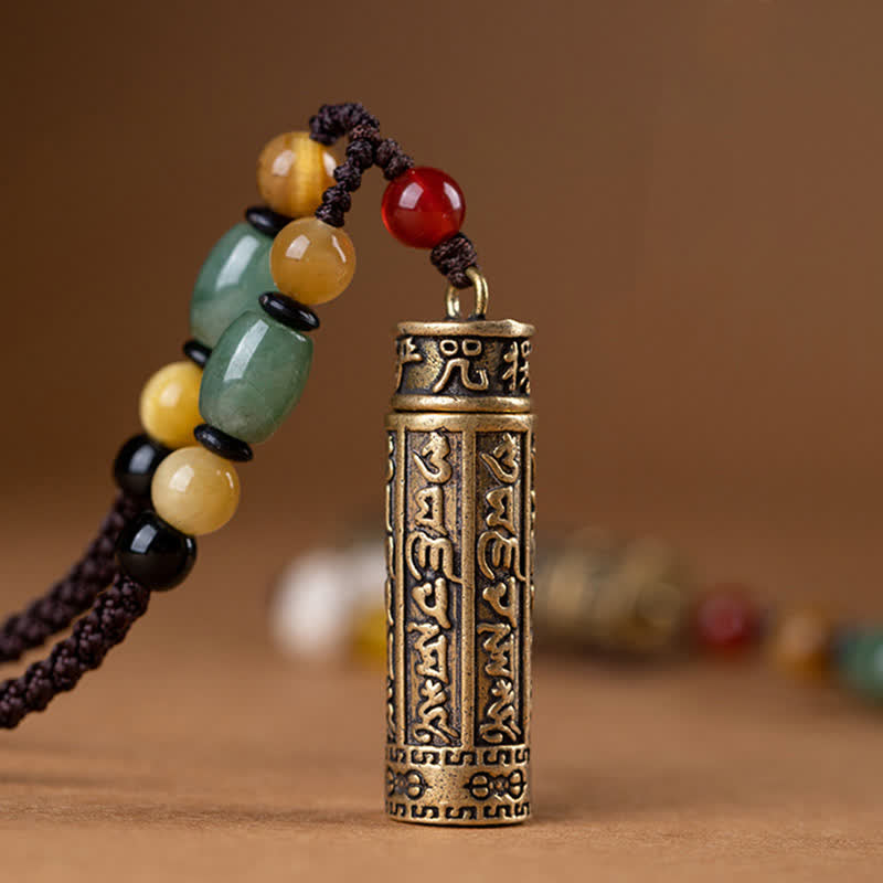 Antique brass Tibetan mantra cylinder pendant with engraved Sanskrit script, green aventurine, tiger's eye, and red carnelian beads on braided cord