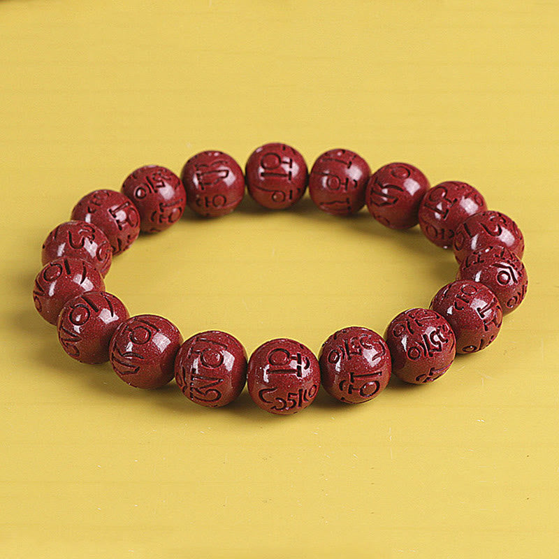 Double PiXiu Cinnabar Bracelet – Close-up of carved cinnabar mantra beads on yellow, spiritual bead bracelet