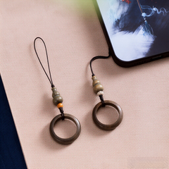 Sandalwood Phone Grip – Two green sandalwood ring grips with gourd beads on beige fabric beside phone, Feng Shui anti-drop charm