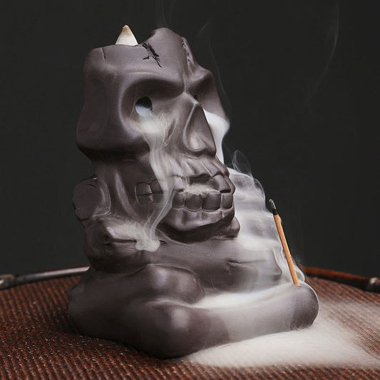 Skull Head Incense Burner – three-quarter angle with dual smoke streams from eyes, purple clay burner