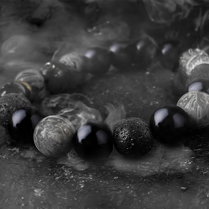Black Obsidian Lava Rock Yin Yang Bracelet - close-up with atmospheric smoke on dark stone, moody lighting, men jewelry
