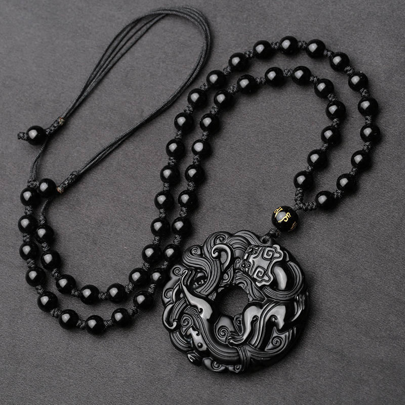 Black Obsidian Pixiu Pendant – Full view of black obsidian pendant on beaded necklace, gray bg