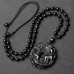 Black Obsidian Pixiu Pendant – Full view of black obsidian pendant on beaded necklace, gray bg