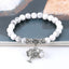 Tree of Life white turquoise bracelet with white howlite beads featuring gray veining, silver tree-of-life charm, silver floral spacers.