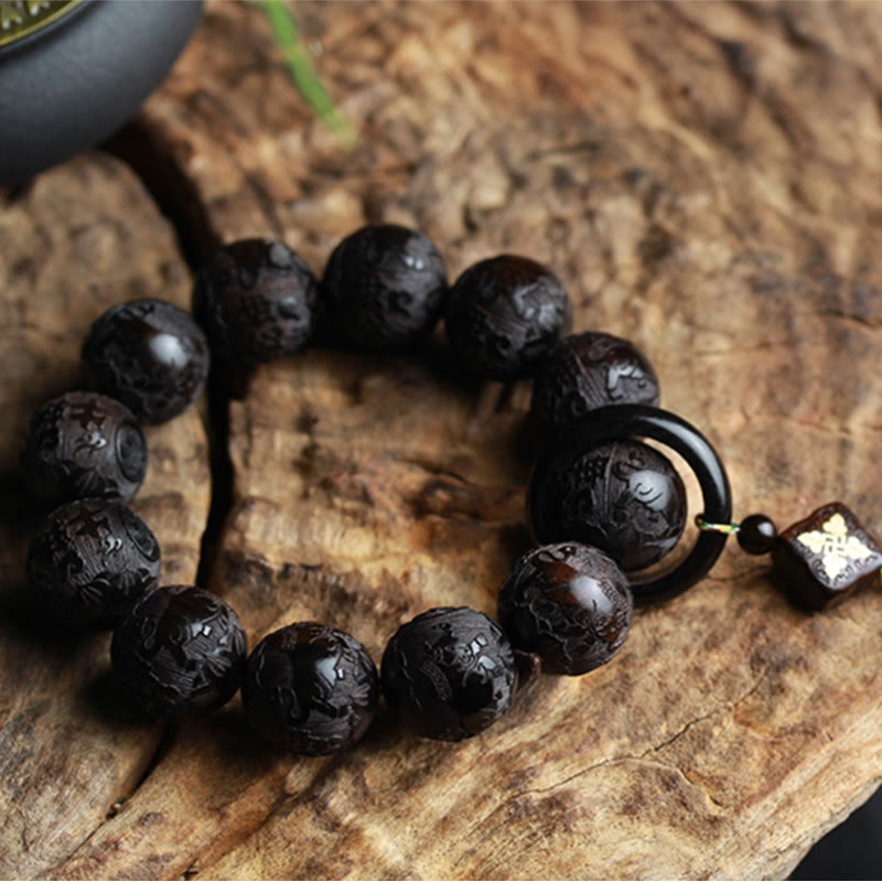 Ebony Wood Yin Yang Gourd Balance Bracelet - overhead view of circular bracelet with butterfly inlay toggle on wood, ebony wood bracelet