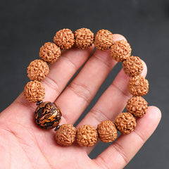 Rudraksha PiXiu Bracelet – Hand holding bodhi seed bracelet with carved copper coin bead, gray background