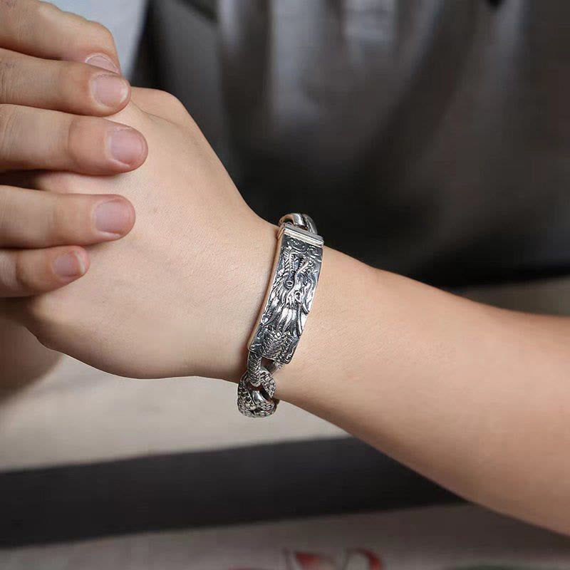 Retro Dragon Bracelet - side angle wood stand blue backdrop, rugged, protective