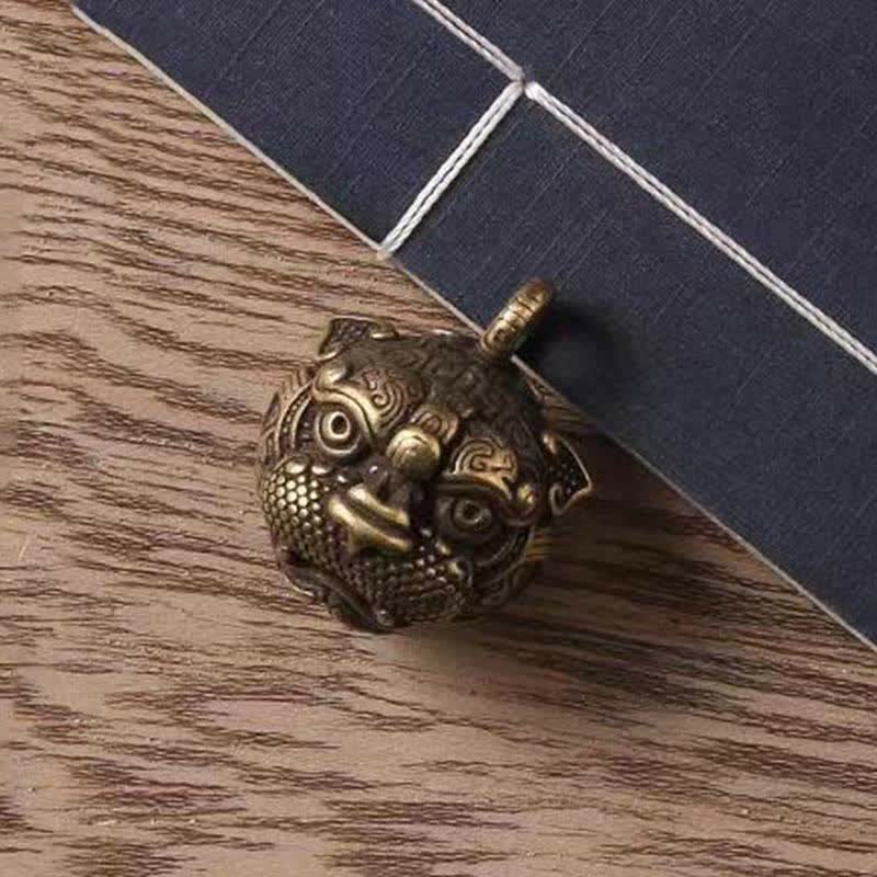Pixiu Wealth Copper Key Chain – pixiu head close-up on wood grain background, detailed facial carving texture