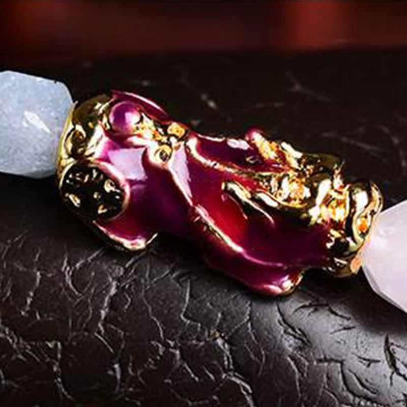 Natural Amethyst Pixiu Bracelet – macro red purple pixiu charm with gold edges on black stone background detail